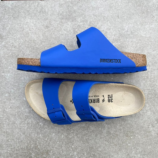 Blue Birkenstock sandals on a gray surface