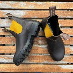 Pair of Black Leather boots with yellow lining outdoors
