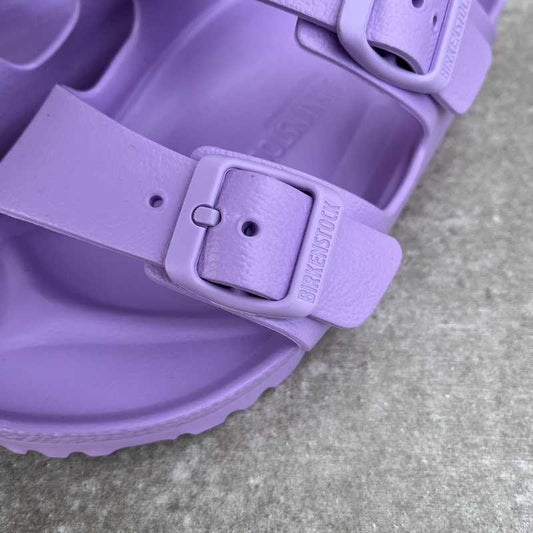 Close-up of a purple waterproof sandal with a waterproof buckle on a concrete surface