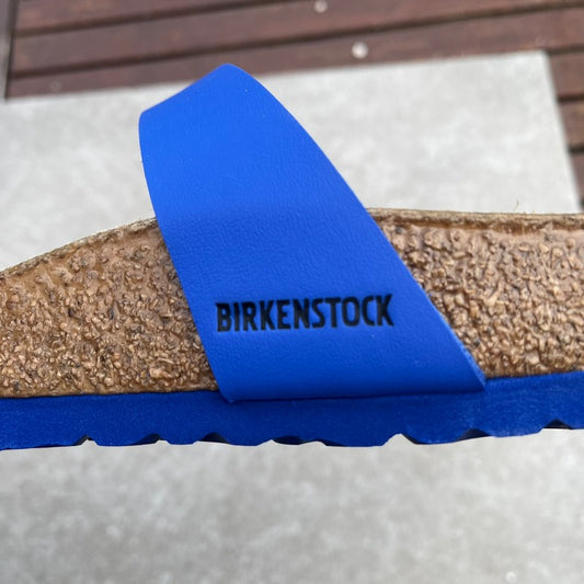 Birkenstock sandal with a blue strap on a blue sole