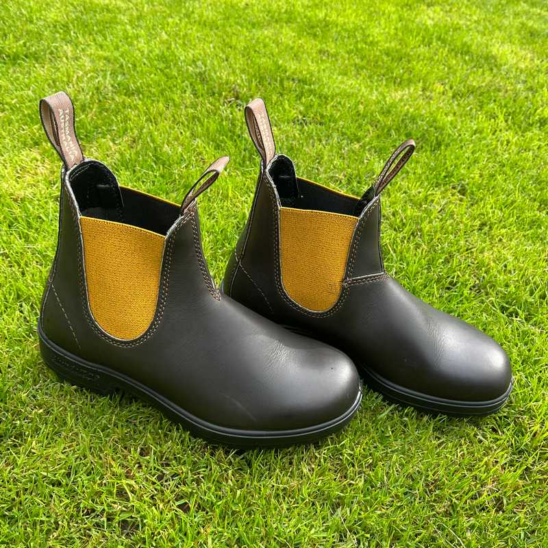 Pair of Brown boots with mustard accents in the garden