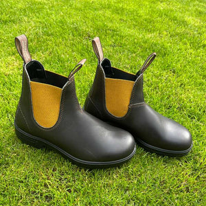 Pair of Brown boots with mustard accents in the garden