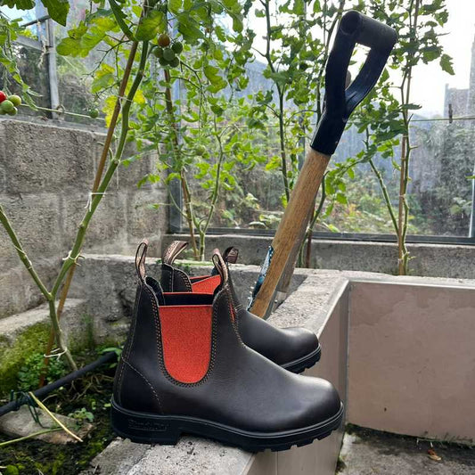 Brown Leather Blundstone boots with orange lining in the garden.
